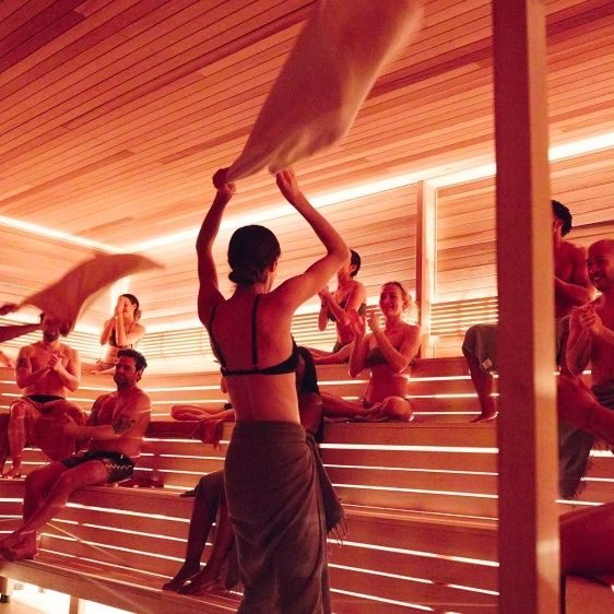 Sauna master waving a towel during an Aufguss session